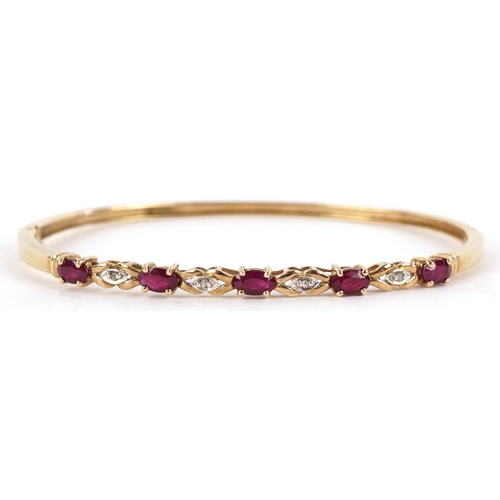 3012 - A 9ct gold ruby and diamond bangle, 6.5cm wide, 7.3g.