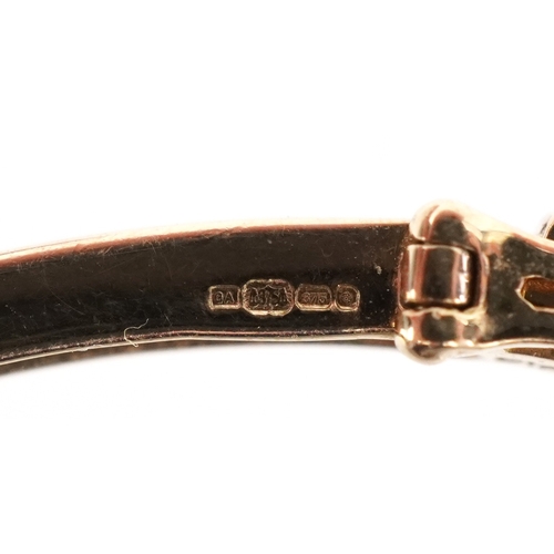 3012 - A 9ct gold ruby and diamond bangle, 6.5cm wide, 7.3g.