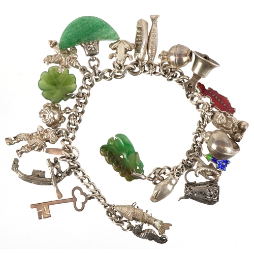 3442 - A silver charm bracelet with mostly silver charms including a seahorse, clown and a filigree jug, 57... 
