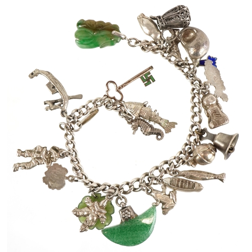 3442 - A silver charm bracelet with mostly silver charms including a seahorse, clown and a filigree jug, 57... 