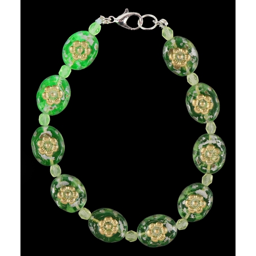 3387 - A uranium glass bead bracelet with floral design, 19cm in length, 14.1g.
