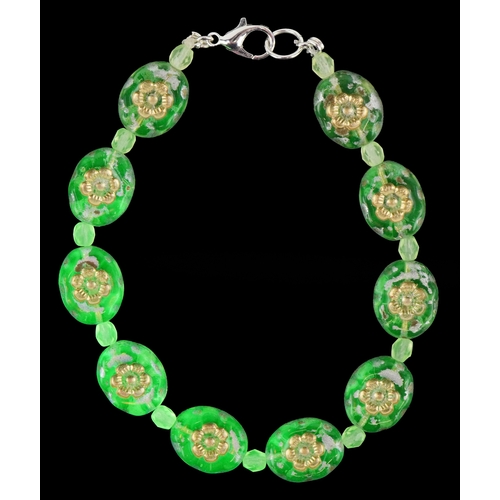 3387 - A uranium glass bead bracelet with floral design, 19cm in length, 14.1g.