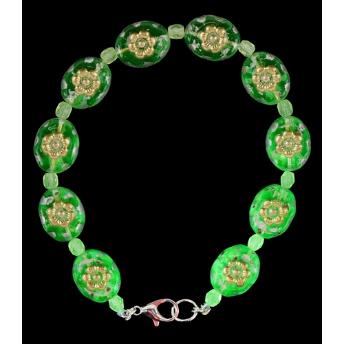 3387 - A uranium glass bead bracelet with floral design, 19cm in length, 14.1g.