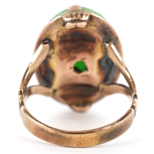 3071 - A Chinese unmarked gold cabochon green stone ring, tests as jade, the stone 2.1cm in length, size M/... 