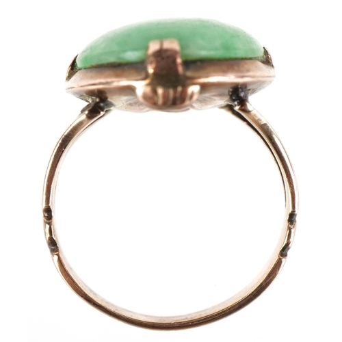 3071 - A Chinese unmarked gold cabochon green stone ring, tests as jade, the stone 2.1cm in length, size M/... 