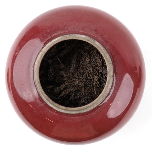 86 - A large Chinese porcelain vase and cover with sang de boeuf glaze, raised on an ebonised carved wood... 