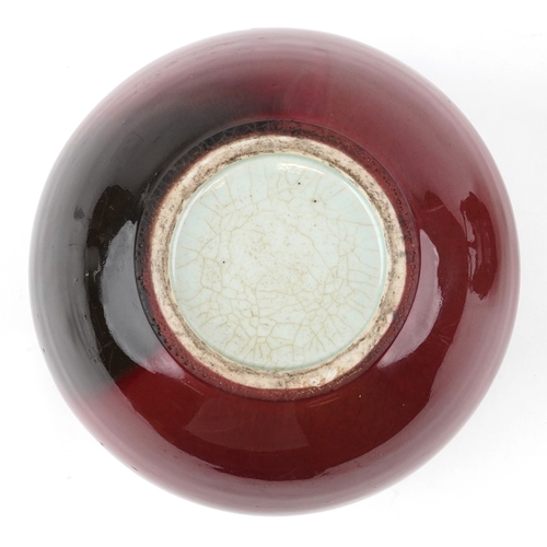 86 - A large Chinese porcelain vase and cover with sang de boeuf glaze, raised on an ebonised carved wood... 