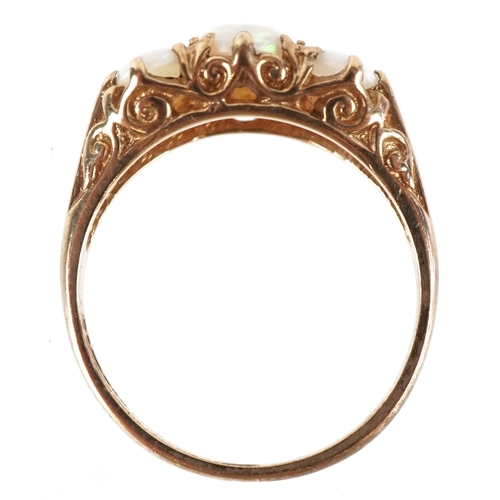 3120 - A 9ct gold graduated opal trilogy ring, size L/M, 2.4g.