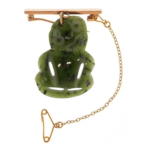 3134 - A 14KT gold and carved green stone Tiki brooch, possibly Maori, 4cm high, 5.7g.