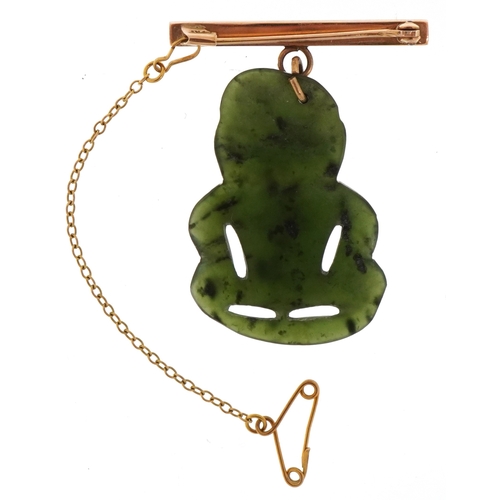 3134 - A 14KT gold and carved green stone Tiki brooch, possibly Maori, 4cm high, 5.7g.