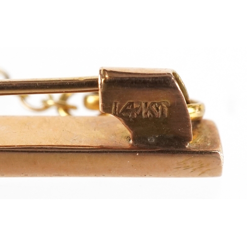 3134 - A 14KT gold and carved green stone Tiki brooch, possibly Maori, 4cm high, 5.7g.