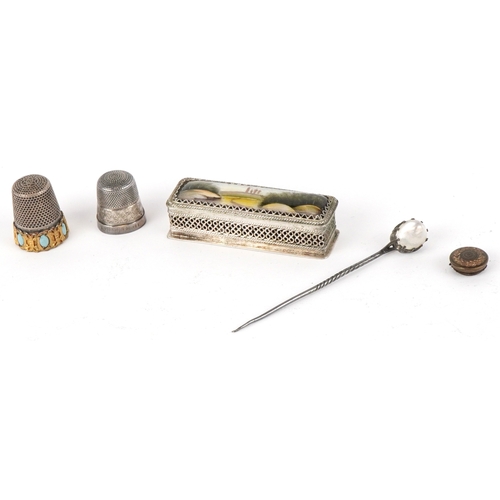 1468 - A small group of objects of Vertu including a moonstone mounted hatpin, two thimbles and a needle ca... 