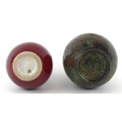 452 - A Chinese patinated bronze bottleneck vase together with a diminutive porcelain vase having a sang d... 