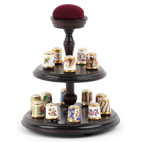 669 - A set of fifteen Royal Crown Derby porcelain thimbles with hardback book and two tier display stand,... 