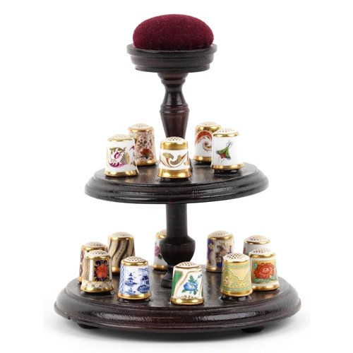 669 - A set of fifteen Royal Crown Derby porcelain thimbles with hardback book and two tier display stand,... 