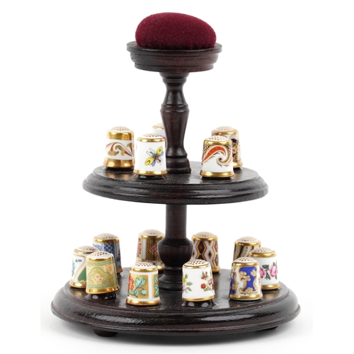 669 - A set of fifteen Royal Crown Derby porcelain thimbles with hardback book and two tier display stand,... 