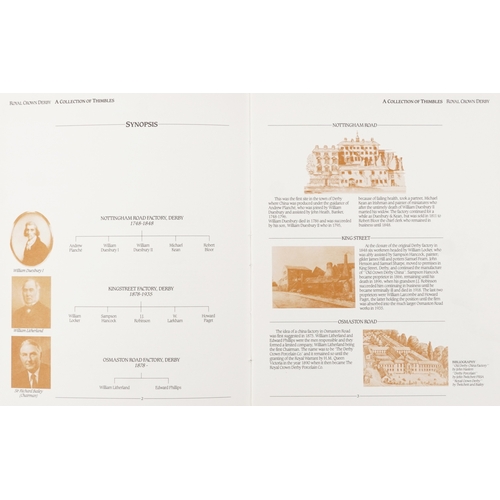 669 - A set of fifteen Royal Crown Derby porcelain thimbles with hardback book and two tier display stand,... 
