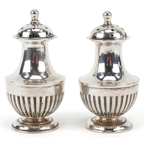 3662 - Goldsmiths & Silversmiths Co., a pair of Victorian silver demi fluted casters housed in a velvet and... 