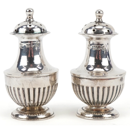 3662 - Goldsmiths & Silversmiths Co., a pair of Victorian silver demi fluted casters housed in a velvet and... 