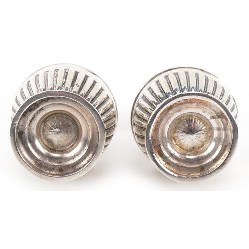 3662 - Goldsmiths & Silversmiths Co., a pair of Victorian silver demi fluted casters housed in a velvet and... 