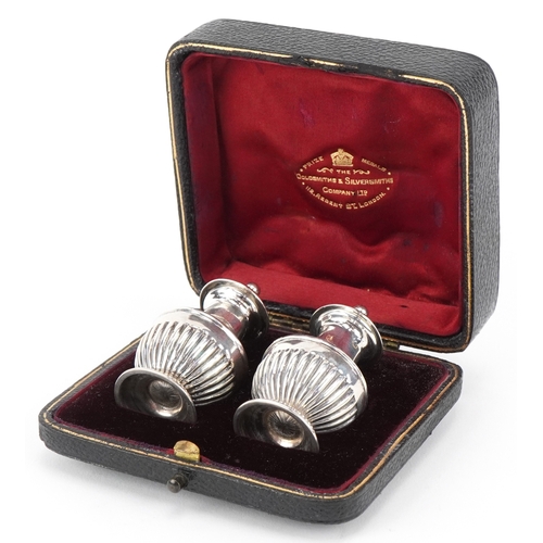 3662 - Goldsmiths & Silversmiths Co., a pair of Victorian silver demi fluted casters housed in a velvet and... 
