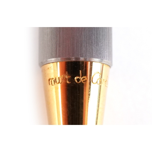 54 - Cartier, a stainless steel and gold plated Must de Cartier ballpoint pen numbered B95471, with box a... 