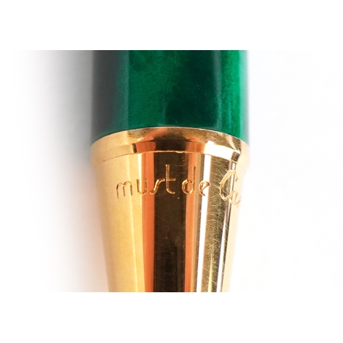 55 - Cartier, a malachite design and gold plated ballpoint pen numbered B85336, with box and paperwork.