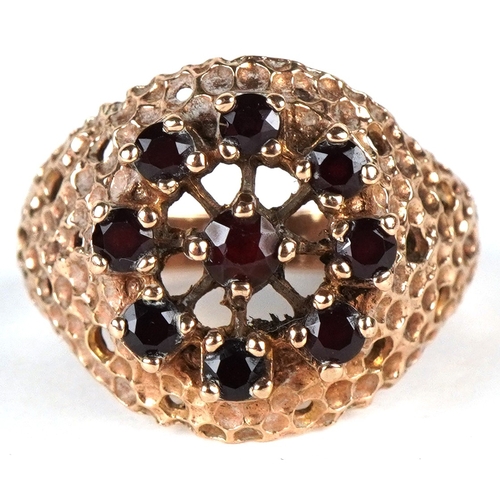 3261 - A 9ct gold garnet cluster ring with textured shoulders, size N, 4.1g.