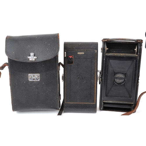 1061 - A Ciné-Kodak model BB Junior camera, cased, together with a folding camera within a brown leather ca... 