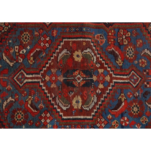 2204 - A small Heriz rug, 20th century, the red field with a central stylized motif flanked by birds within... 