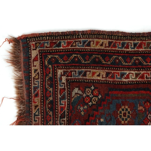 2204 - A small Heriz rug, 20th century, the red field with a central stylized motif flanked by birds within... 