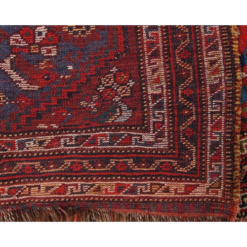 2204 - A small Heriz rug, 20th century, the red field with a central stylized motif flanked by birds within... 