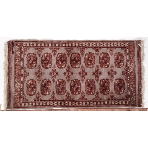 2206 - A Pakistan Bokhara rug, 20th century, the grey field with two columns of guls within a complementary... 