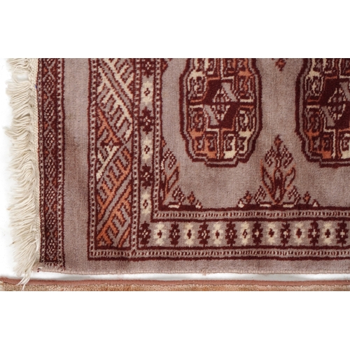 2206 - A Pakistan Bokhara rug, 20th century, the grey field with two columns of guls within a complementary... 