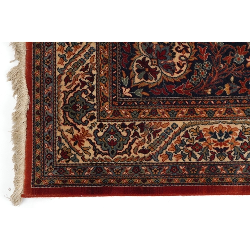 2224 - A Kashan rug, 20th century, the blue field with a central scrolling flower head motif within a compl... 