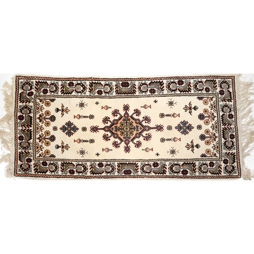 2210 - A Tunisian wool rug, modern, the white field with a central stylized medallion within a complementar... 
