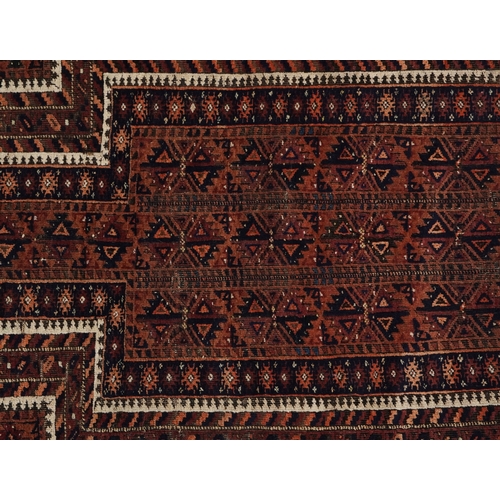 2211 - A Baluch prayer rug, 20th century, the brown field with an asymmetrical central panel within a flowe... 