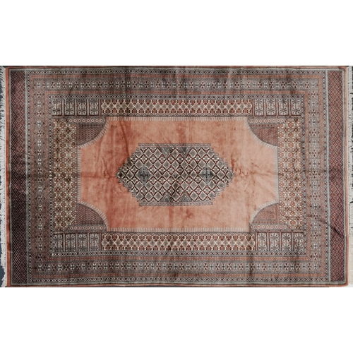 2225 - A Pakistani carpet, late 20th century, the salmon pink field with a central stylized medallion withi... 