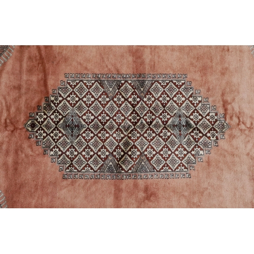 2225 - A Pakistani carpet, late 20th century, the salmon pink field with a central stylized medallion withi... 