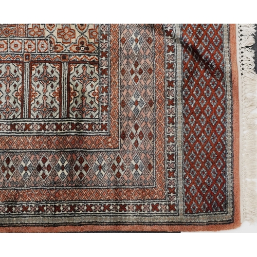 2225 - A Pakistani carpet, late 20th century, the salmon pink field with a central stylized medallion withi... 