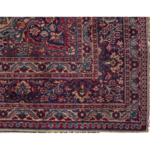 2222 - A Persian rug, 20th century, the blue field with a central lobed medallion with scrolling flower hea... 