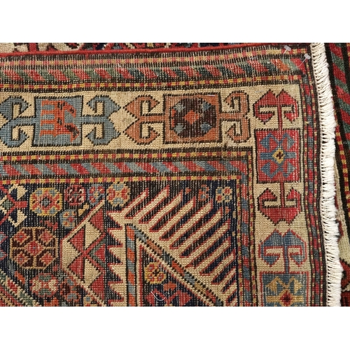 2209 - A Caucasian runner, 20th century, the blue field with four stylized flower head motifs within a comp... 