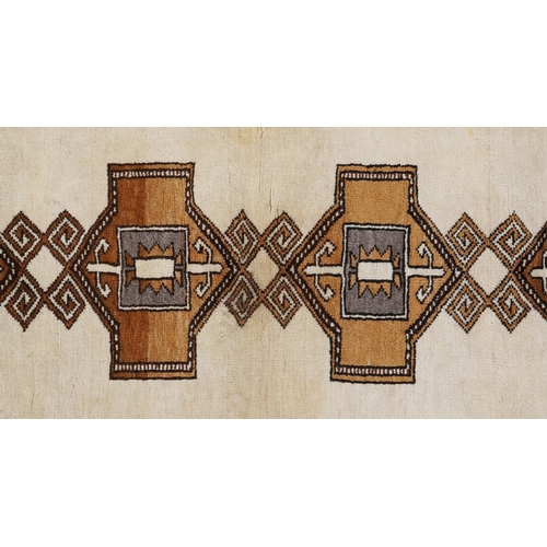 2203 - A Persian runner, the ivory field with four central medallions within a grey border, 212cm x 102cm.