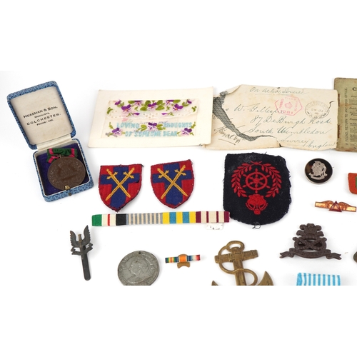 2818 - A collection of military interest medals, driving awards, cap badges and commemorative medals includ... 