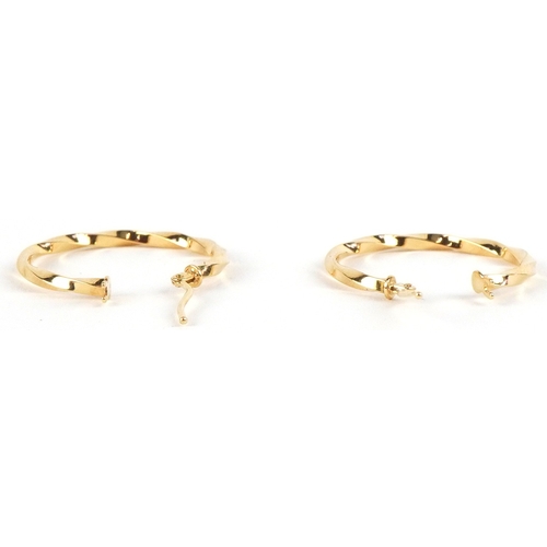 3256 - A pair of as new 9ct gold twisted hoop earrings  retailed by Goldsmiths, with box, 2.3cm in diameter... 