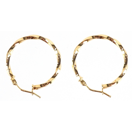 3256 - A pair of as new 9ct gold twisted hoop earrings  retailed by Goldsmiths, with box, 2.3cm in diameter... 