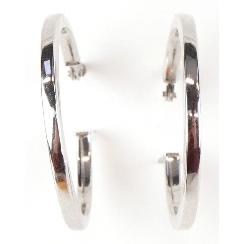3096 - A pair of as new 9ct white gold hoop earrings retailed by Goldsmiths, with box, 2.6cm in diameter, t... 