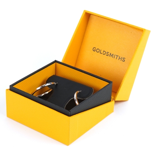 3096 - A pair of as new 9ct white gold hoop earrings retailed by Goldsmiths, with box, 2.6cm in diameter, t... 