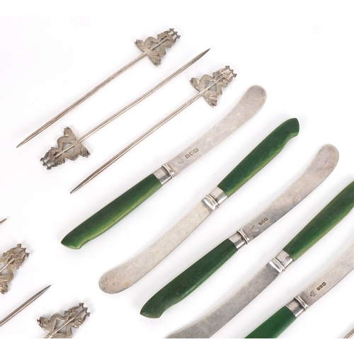 1865 - Five antique silver bladed butter knives and seventeen silver plated skewers in the form of mythical... 