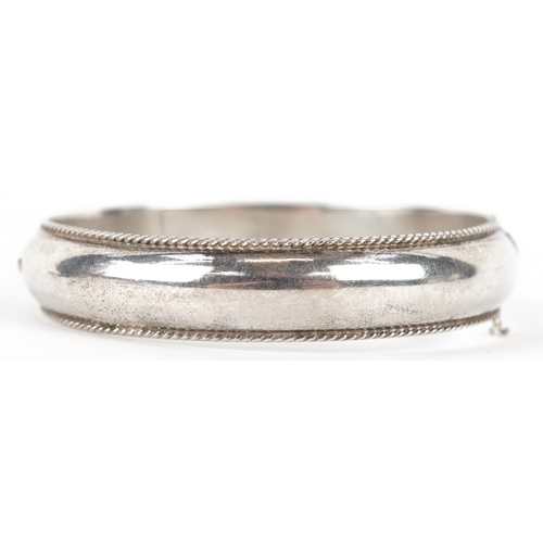 3225 - A silver hinged bangle, 6.8cm in diameter, 20.4g.